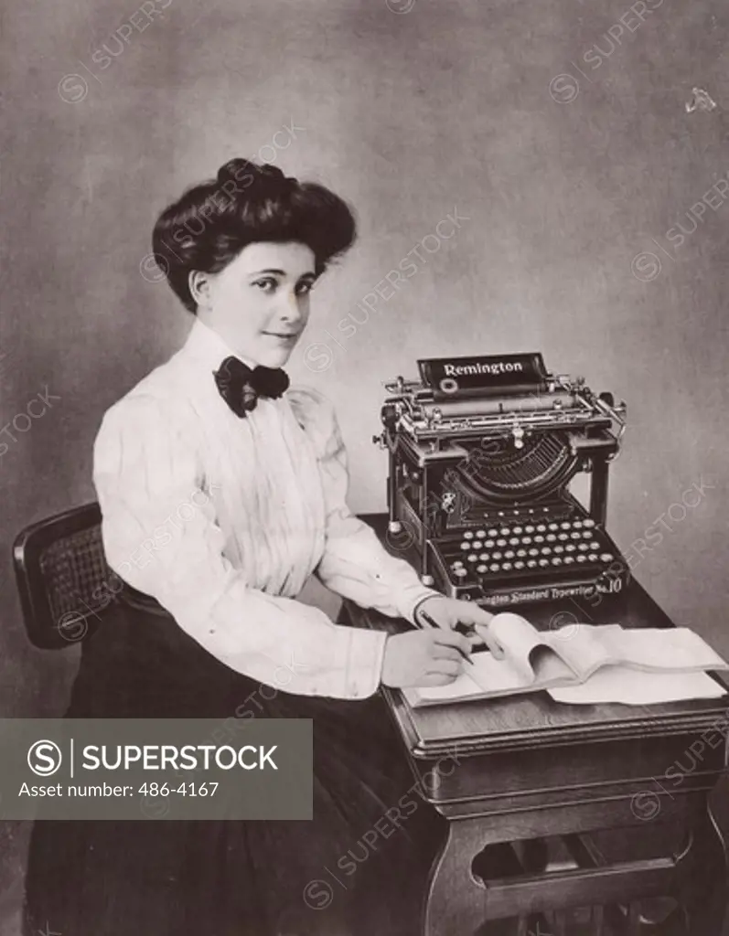 Portrait of young woman making notes at desk