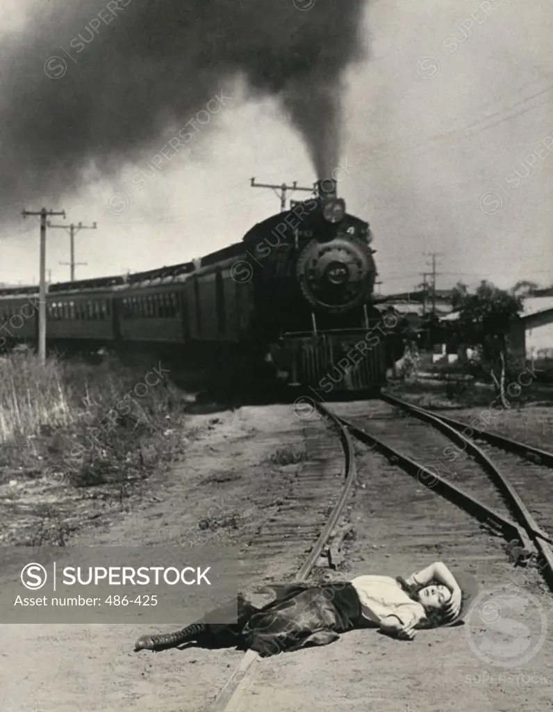 Young woman lying on a railroad track