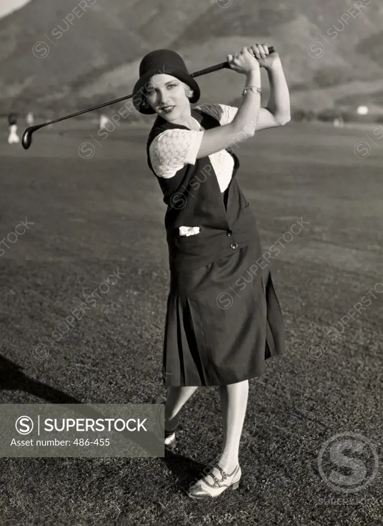 Portrait of a young woman playing golf