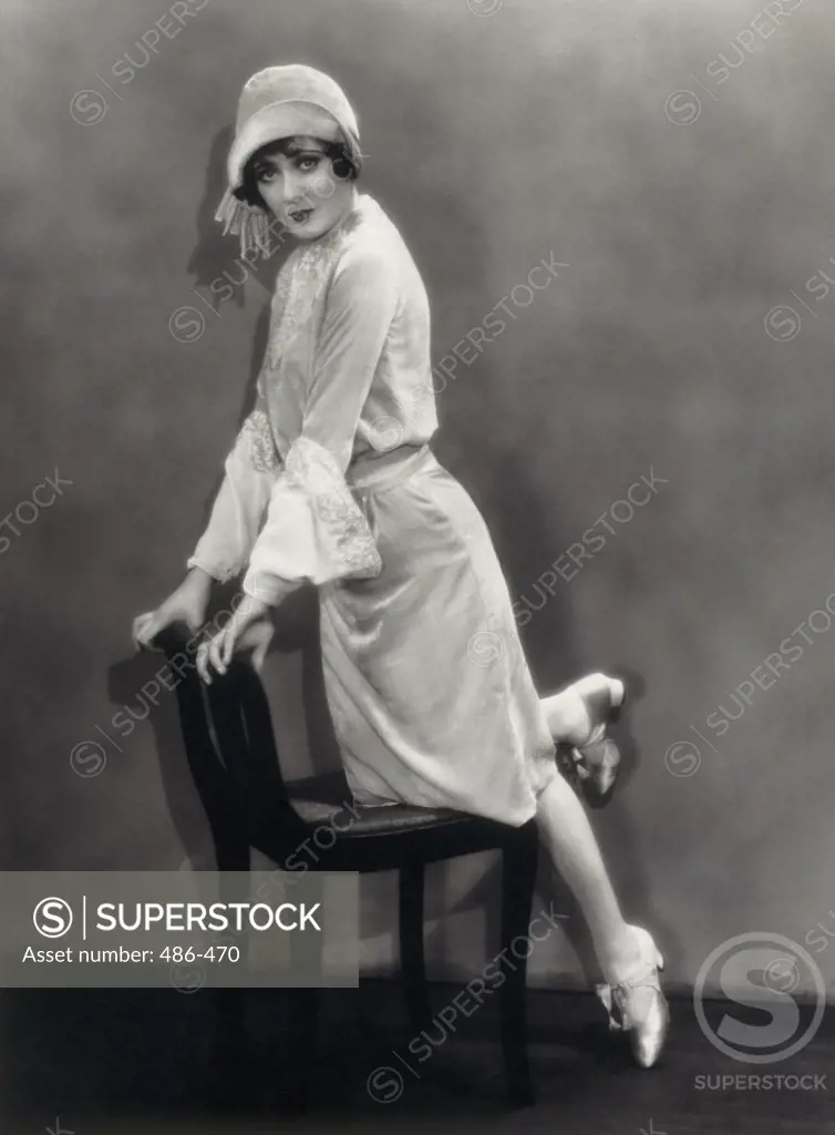 Portrait of a young woman leaning on a chair