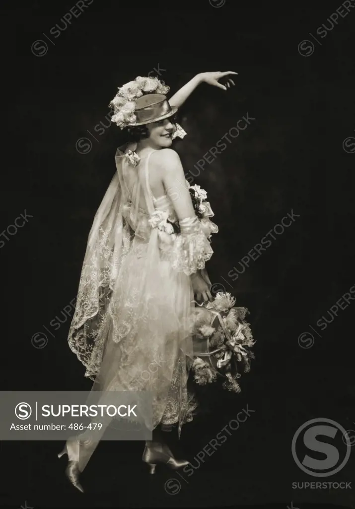 Rear view of a young woman holding a basket full of flowers