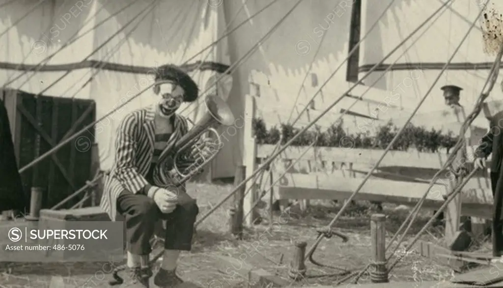 Clown playing trumpet in circus