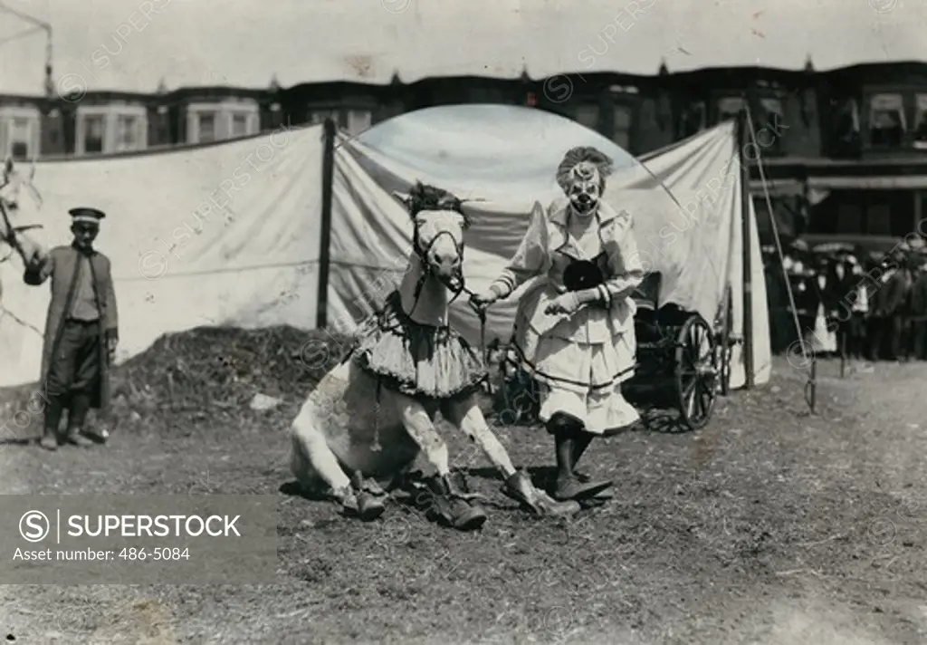 Clown with horse next to circus tent