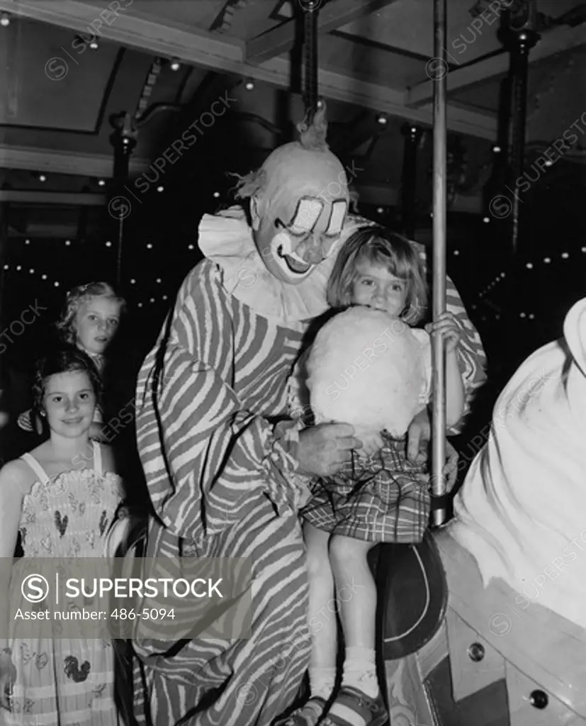 Clarabel, Tv's ""howdy doody"" clown, treating girl to wad of cotton candy on carouse at Patisades Park, 1951