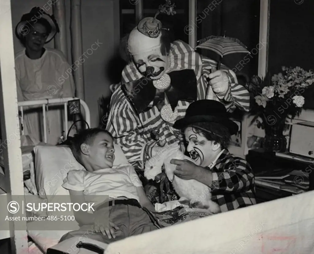 Clowns performing trick for ill boy