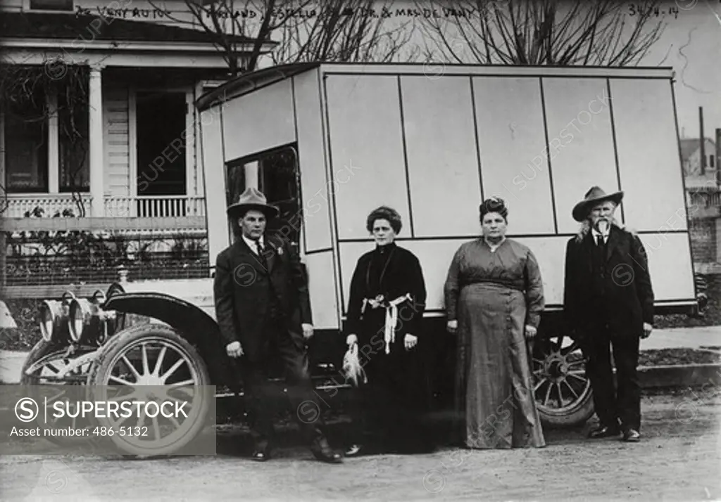 People standing next to circus wagon