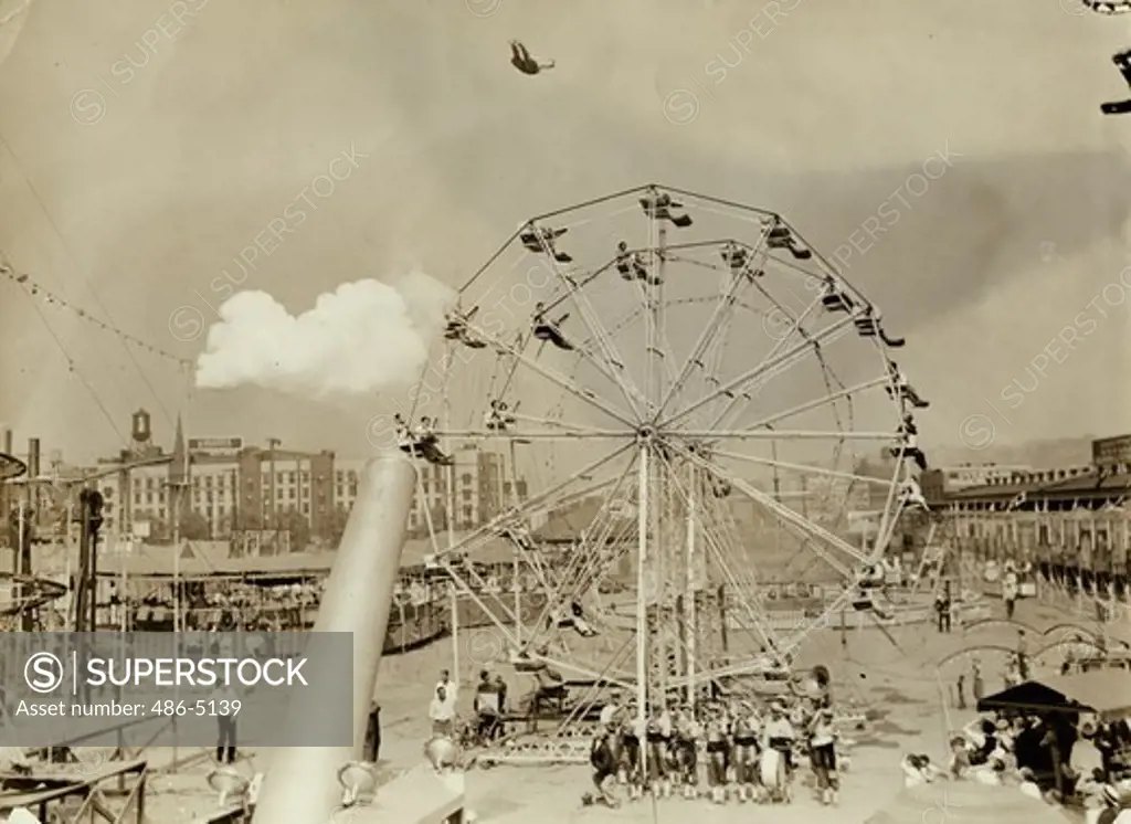USA, Pennsylvania, Pittsburg, View of Great Zacchini trick, 1936, Pittsburg, A remarkable photograph, made by a Sun-Telegraph photographer, that shows ""The Great Zacchini"", the Man who's short from a cannon every day, flying through the air high over two ferries wheels at an outdoor traveling show. This is the first time that this stunt has ever been photographed, probably the first time that an outdoor, daylight shot of such clarity has been made of the human bullet in full flight