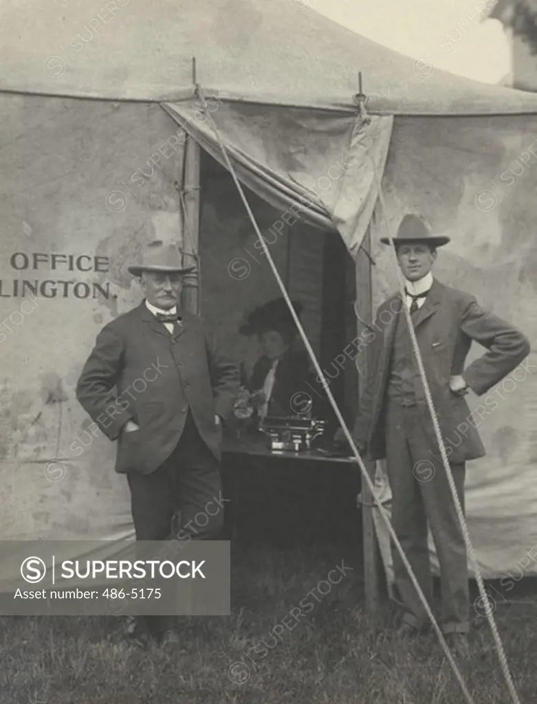 Portrait of men standing in entrance to circus tent