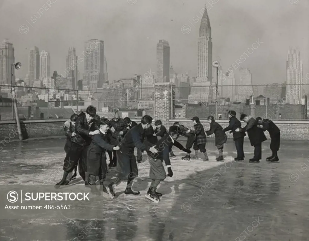 USA, New York State, New York City, Madison Square Boys Club members skating on roof of Jack Frost's building, 1940