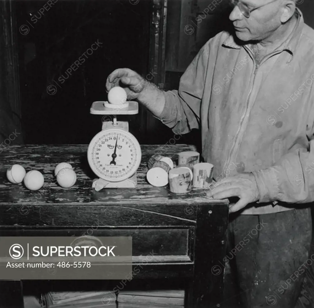 Mature man preparing billard balls in his workshop
