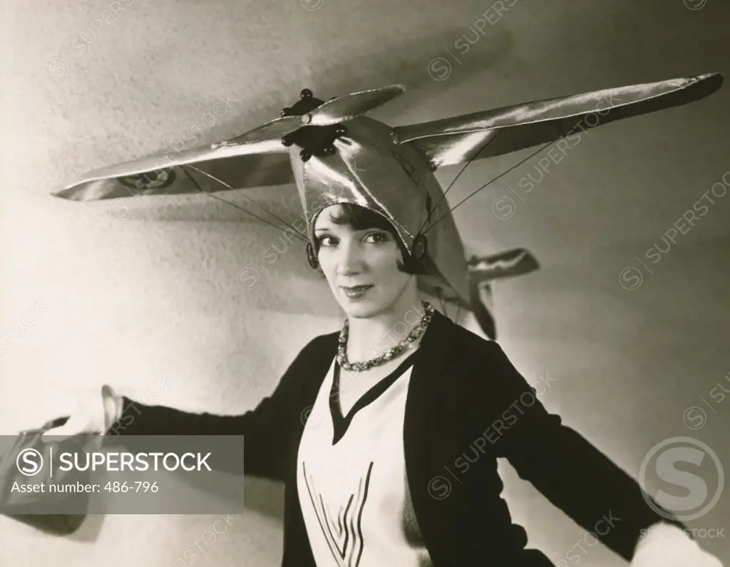 Close-up of a young woman wearing an airplane on her head
