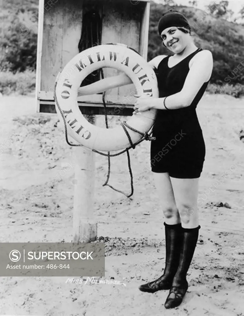 USA, Wisconsin, Milwaukee, Portrait of young woman in swimwear holding life ring