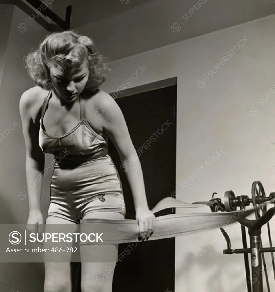 Young woman using vibrating belt - SuperStock