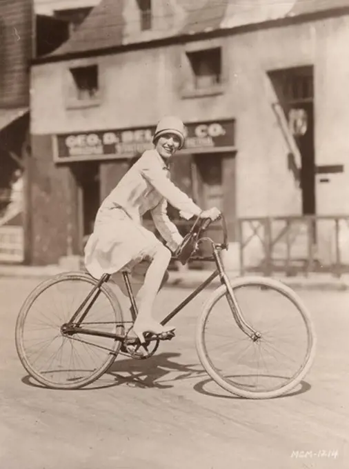 Portrait of Pauline Starke (Metro-Goldwyn-Mayer player) riding bicycle