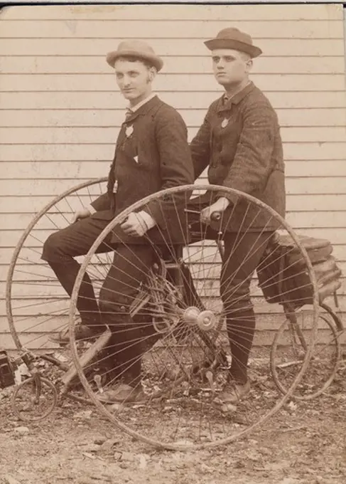 two men posing with tricycle