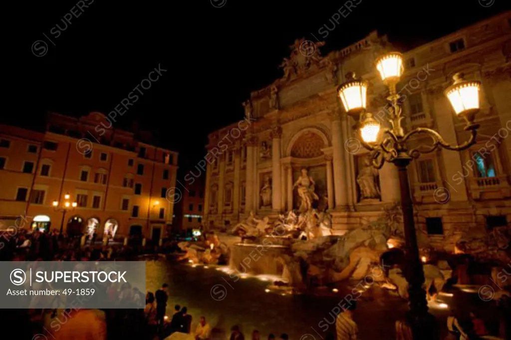 Tourists near a fountain at night, Trevi Fountain, Rome, Italy
