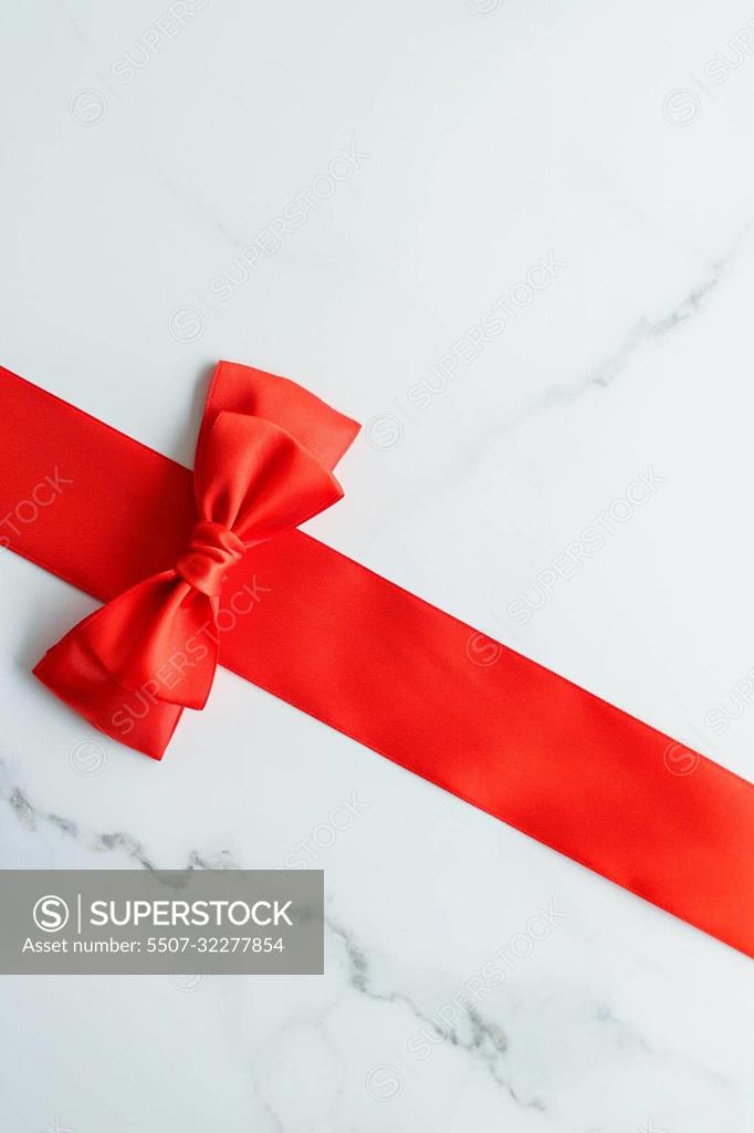 Red silk ribbon on marble, top view - SuperStock