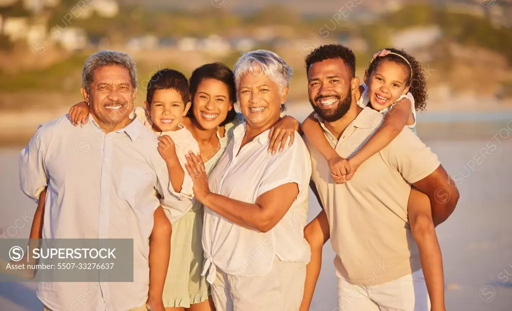Portrait of a multi generation family on vacation standing together at the beach on a sunny day. Mixed race family with two children, two parents and grandparents spending time together
