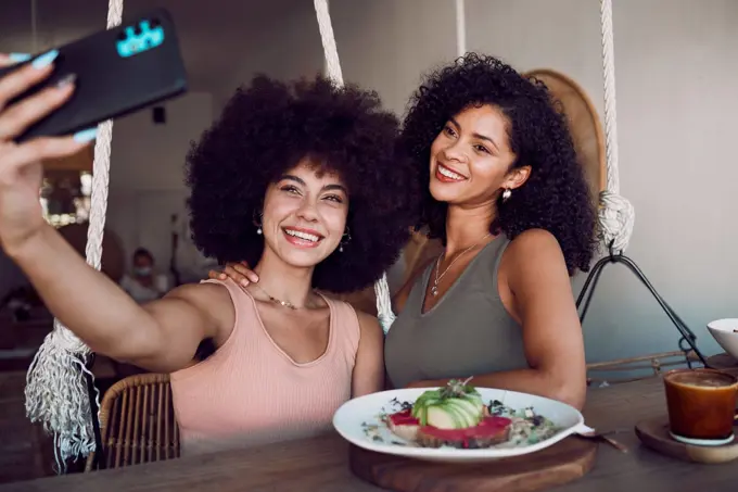 Black women, friends and phone selfie at restaurant, cafe or small business for social media. Relax, tech and females on wifi taking picture with mobile smartphone for happy memory or internet post.