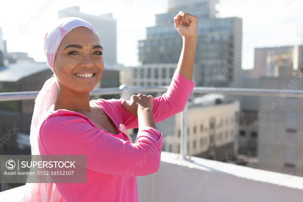 Strong woman wearing mantra scarf in the city with breast cancer awareness
