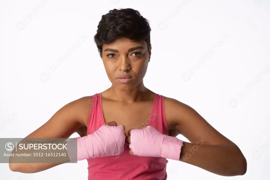 Serious looking woman for breast cancer awareness on white background