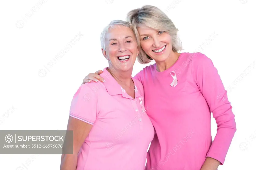 Mature women wearing pink tops and ribbons for breast cancer on white background