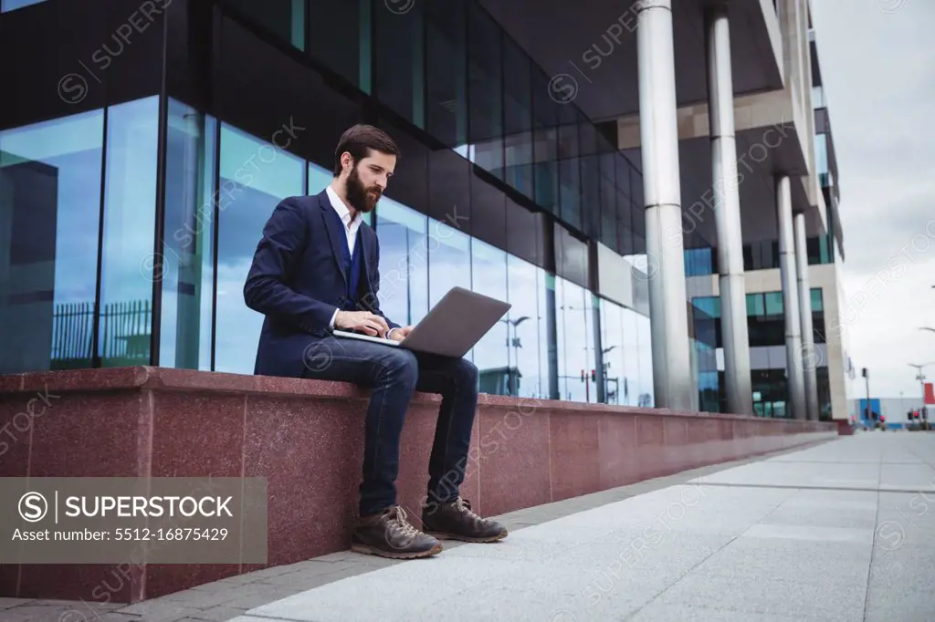 Businessman using mobile phone outside office