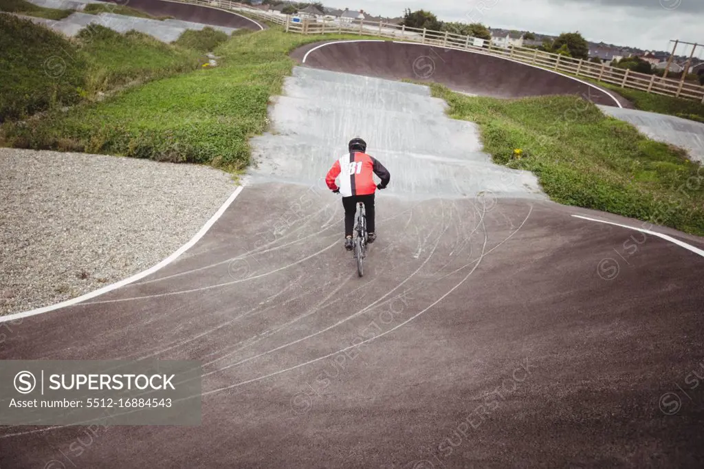 Rear view of cyclist riding BMX bike in skatepark