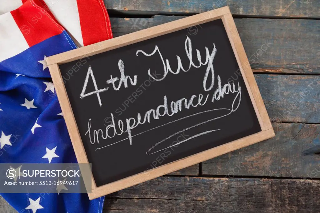 Close-up of American flag and slate with text 4th july independence day