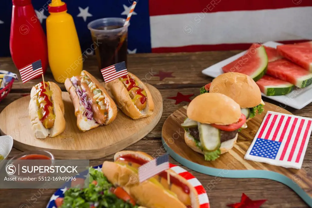 Close-up of American flag and hot dogs on wooden table