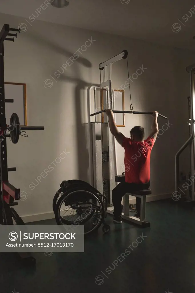 Handicapped man working out lat pulldown training at gym