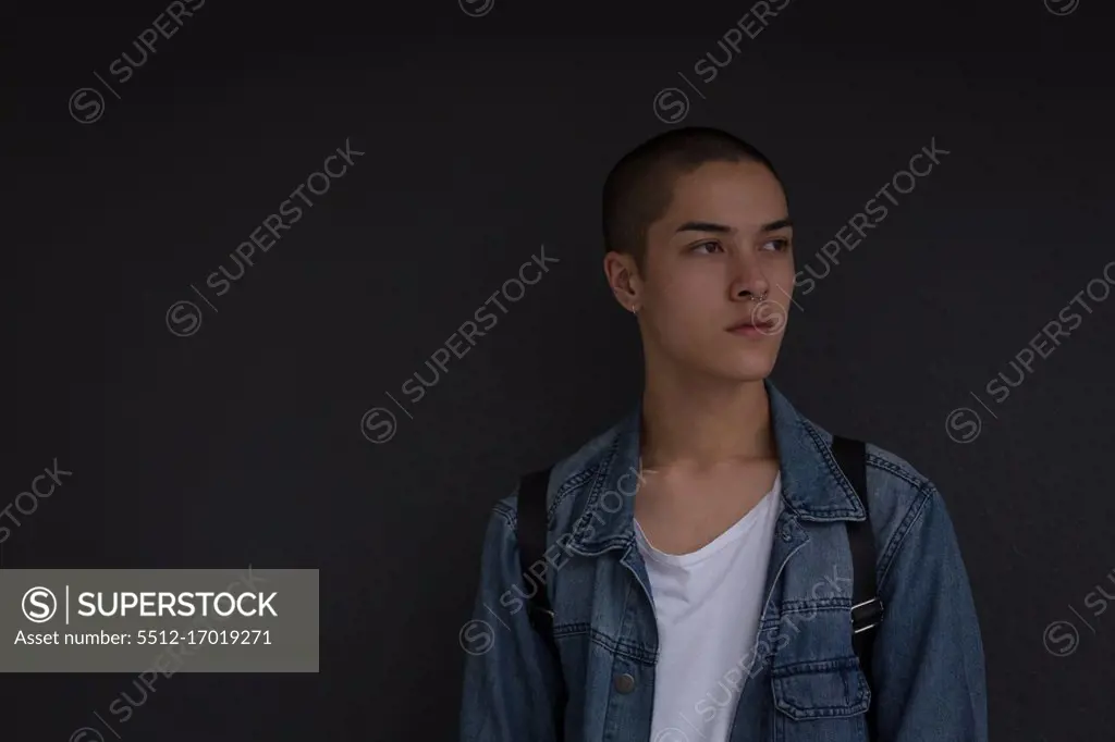 Thoughtful young man leaning against wall