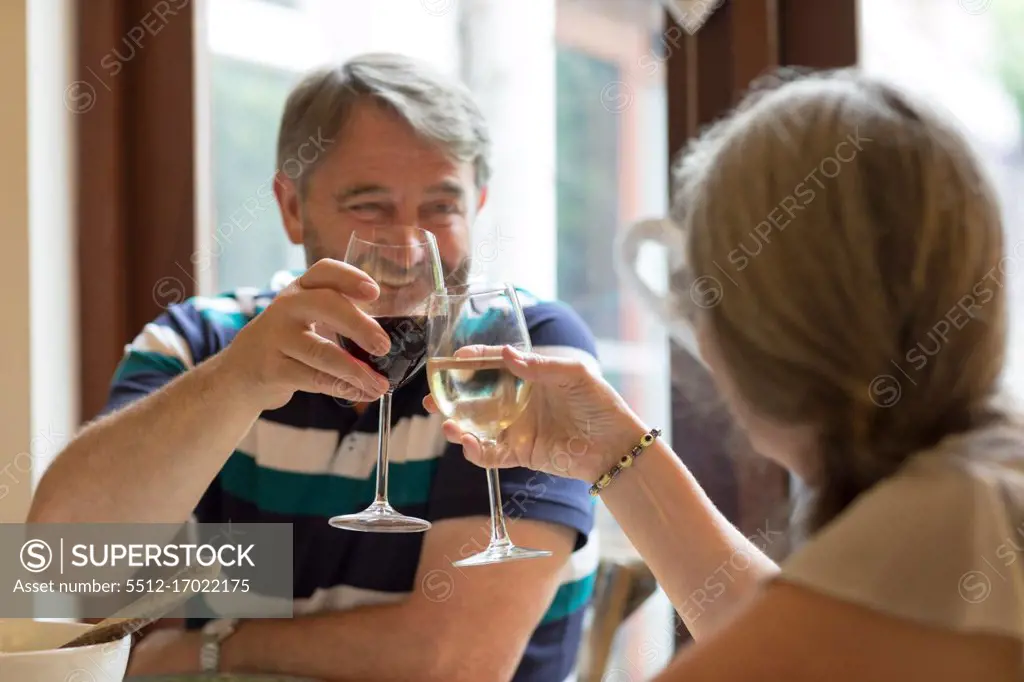 Senior couple toasting glasses of wine at home