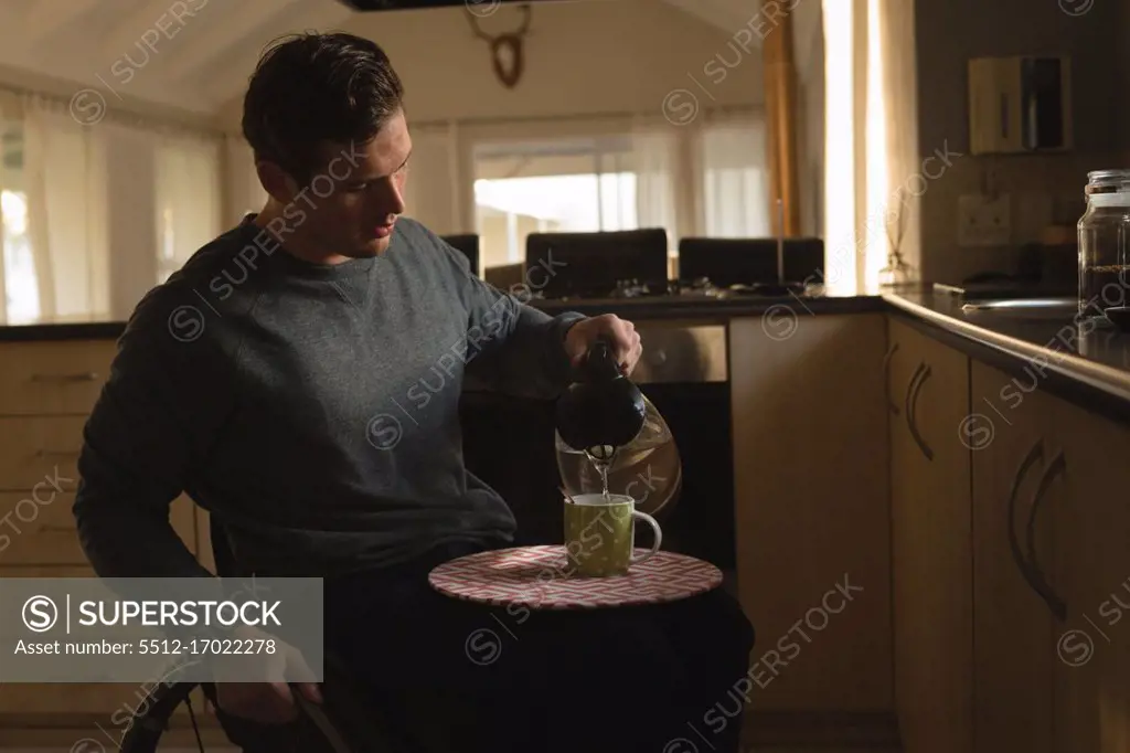 Disabled man preparing coffee in kitchen at home