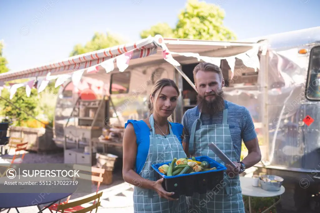 Couple looking at camera near food truck