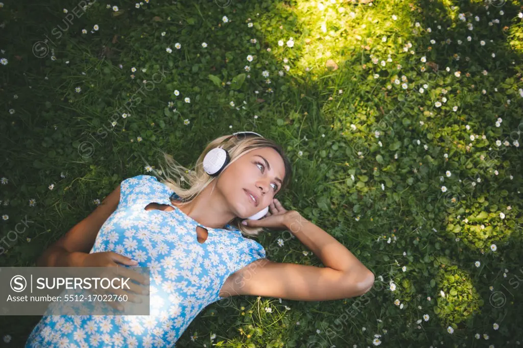 Beautiful woman listening music in garden