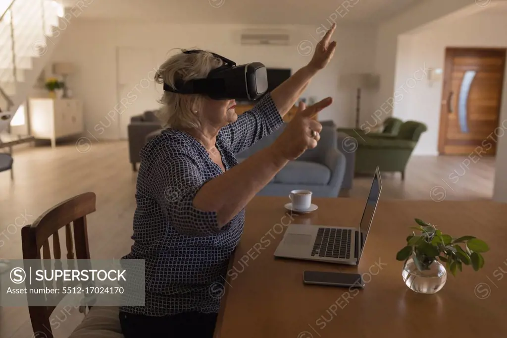 Side view of senior woman using virtual reality headset at home