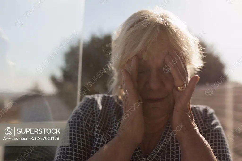 Senior woman suffering from headache in the garden 