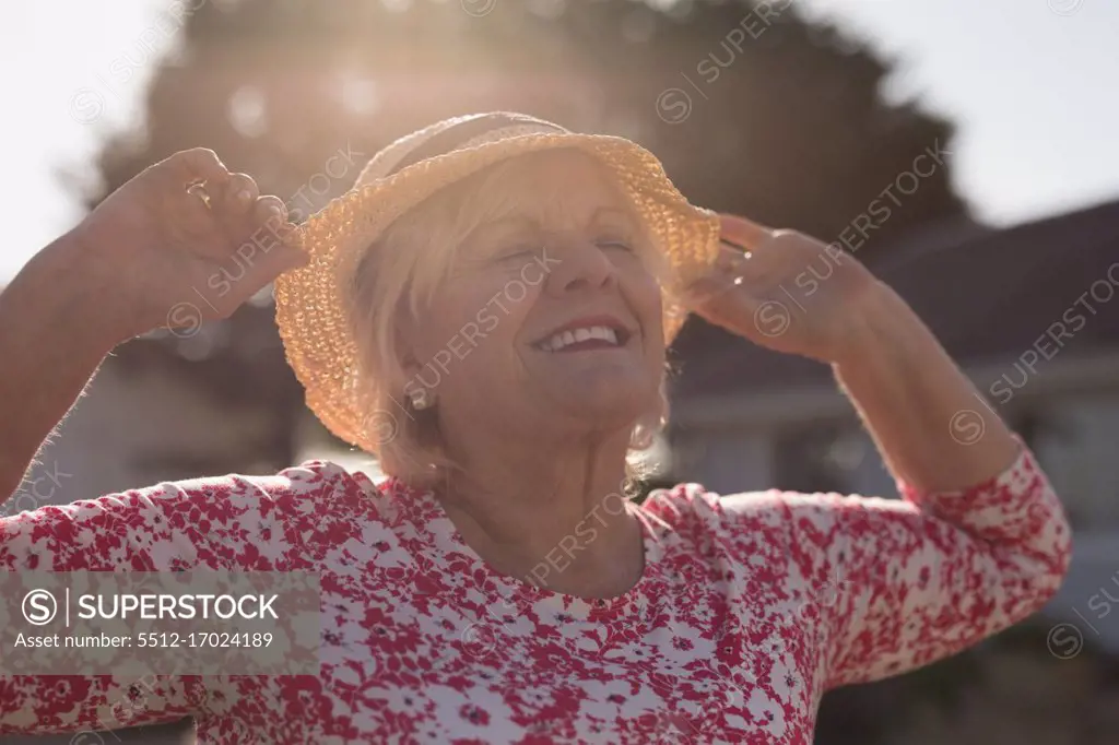 Senior woman dancing in the garden on a sunny day