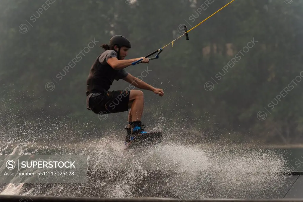 Young man wakeboarding in the river