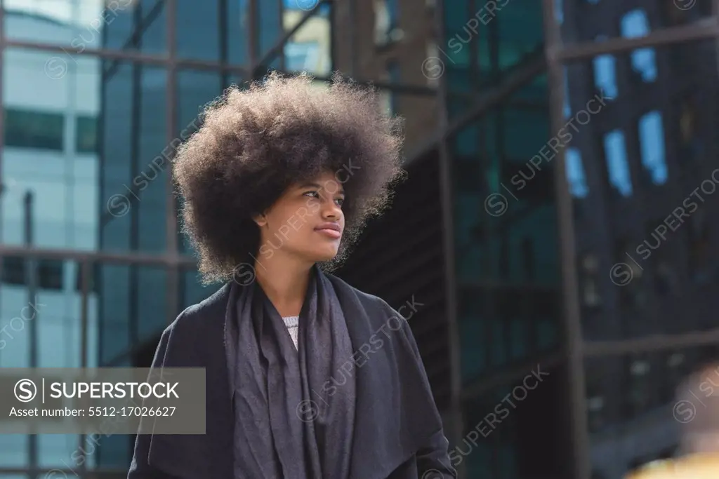 Thoughtful afro woman walking on street