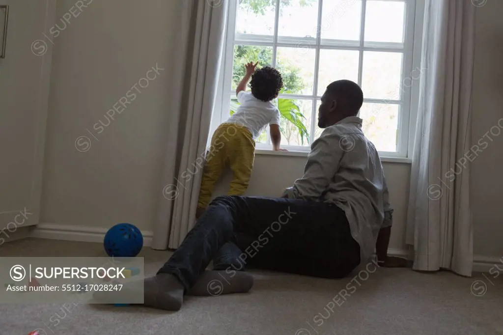Father and son sitting near window at home