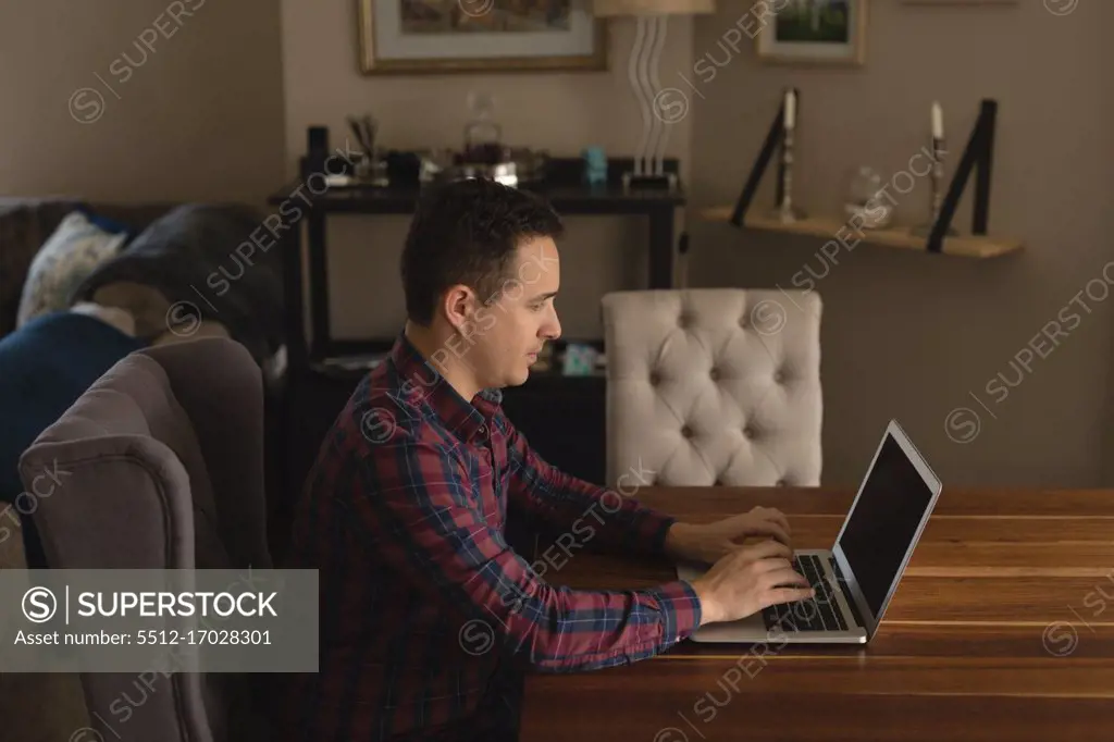 Man using laptop in living room at home