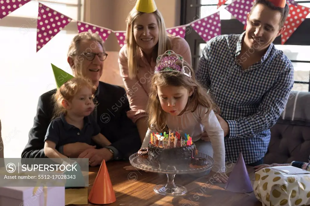 Multi-generation family celebrating birthday in living room at home