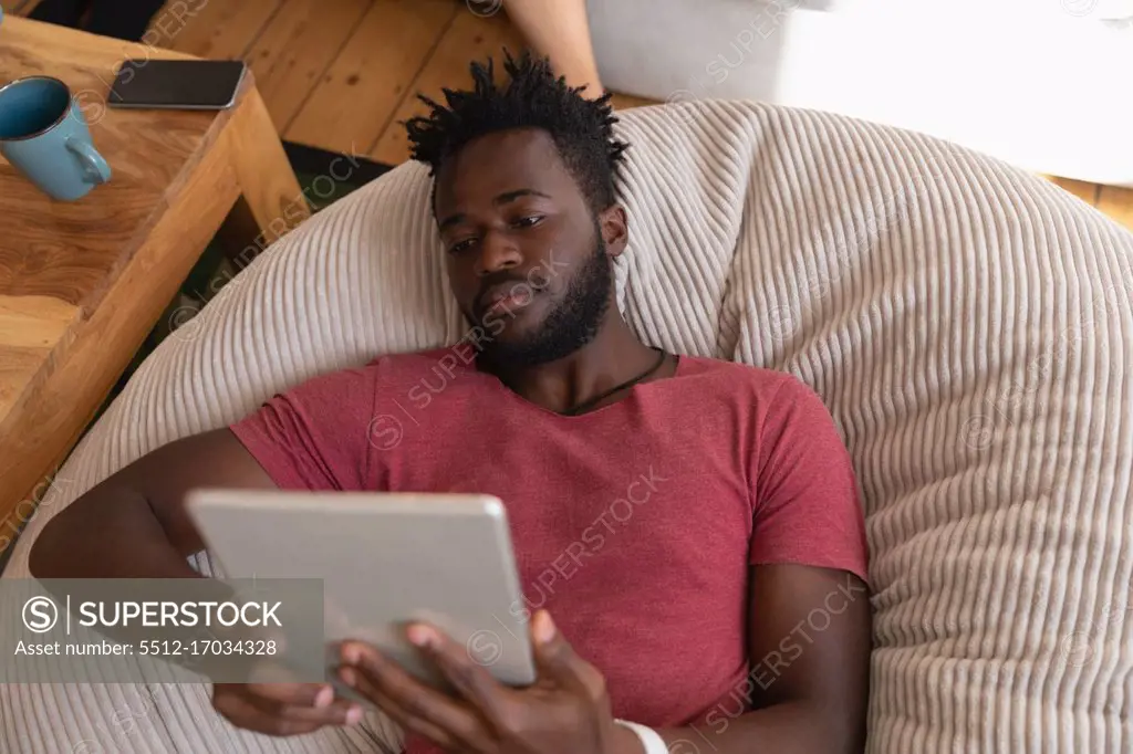 high angle view of African american man using digital tablet in living room at home 