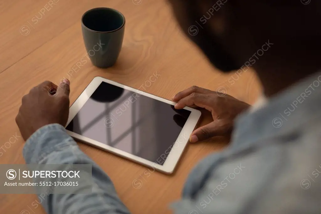 High angle view of man using digital tablet while sitting on chair at home