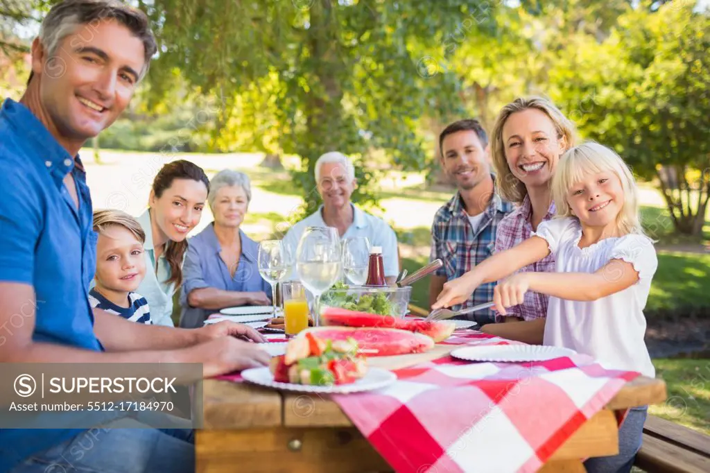 Happy family having picnic and holding american flag on a sunny day