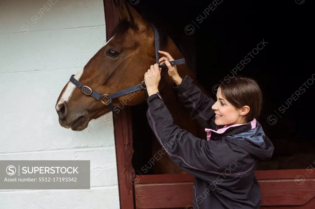 Female rider fixing saddle in the countryside