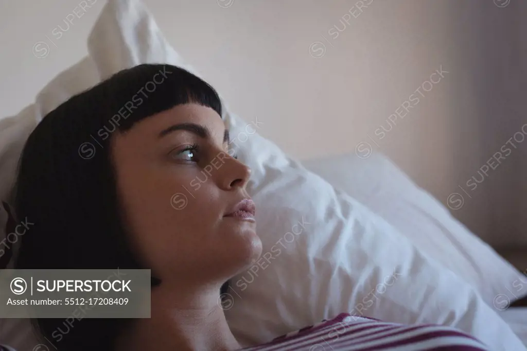 Worried woman relaxing in bedroom at home