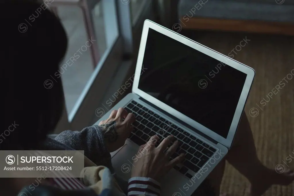 Close-up of woman using laptop at home